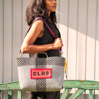 Woman wearing black holding a monochrome CLRS by SAAT tote – modern and minimal.